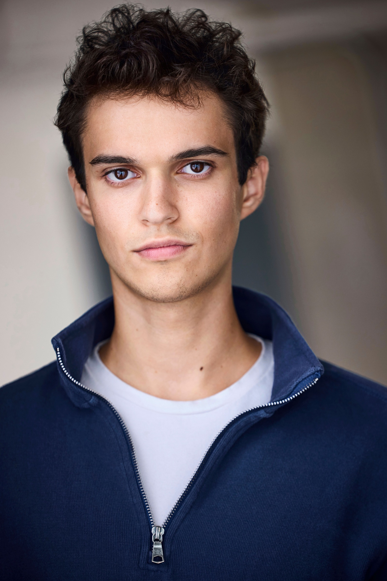 Close-up headshot of Aidan Rex Cook in a navy zip jacket